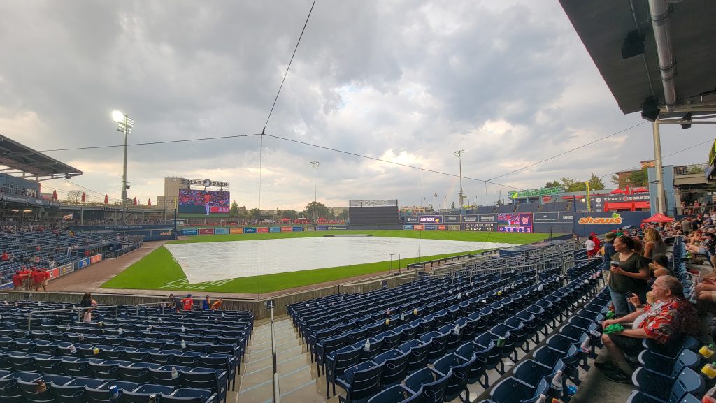 A picture of Polar Park, taken from the first-base side of home plate, looking out toward left field. The field and stadium are we and there are threatenging clouds in the sky.